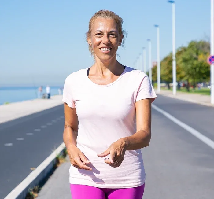 A woman walking outdoors on a bright morning
